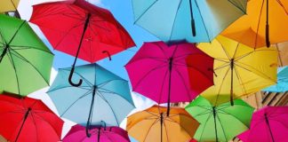 Colorful Umbrellas Float Above a Boutique-Line Passageway In Paris
